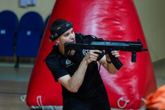 Боец LASERWAR готовится к виртуальному бою у красного препятствия.
